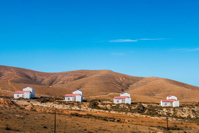 Houses on mountain against blue sky