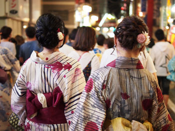 Rear view of women standing outdoors