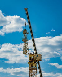 Low angle view of crane against sky