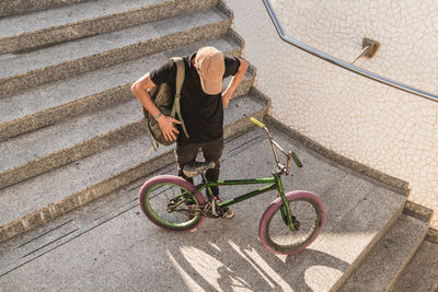 High angle view of man with bicycle on staircase