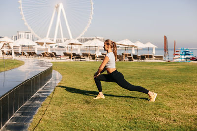 A beautiful woman does yoga on the background of the blue waters island in dubai. sports