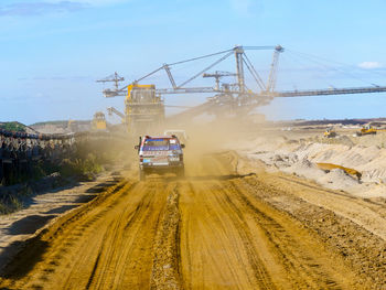 Construction site by road against sky