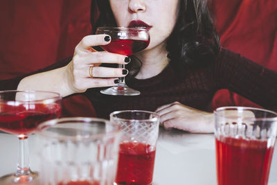 Woman drinking red drink at table