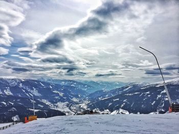 Snow covered mountains against cloudy sky