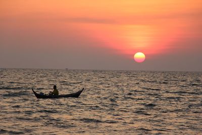 Silhouette of boat in sea at sunset