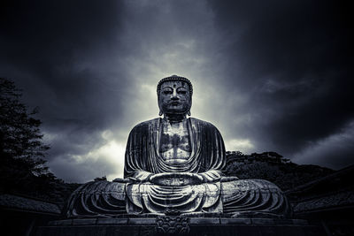 Low angle view of statue against temple against sky