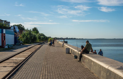 People at beach against sky