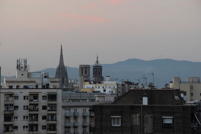 Buildings in city against sky during sunset