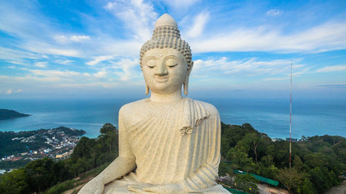 Buddha statue against sea