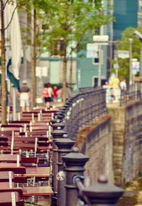 Row of chairs and tables at waterfront of city