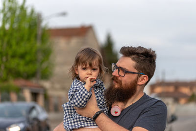 Portrait of father with daughter against blurred background