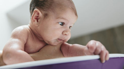 Cropped hand of mother bathing son in bathtub at home