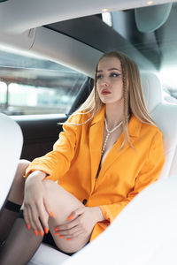 Portrait of young woman sitting in car