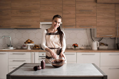 Portrait of chef preparing batter in kitchen