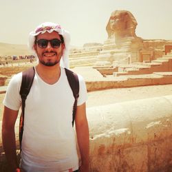 Portrait of smiling man standing against built structure