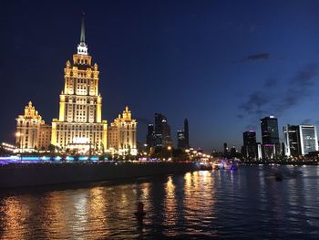 River with illuminated buildings in background at night