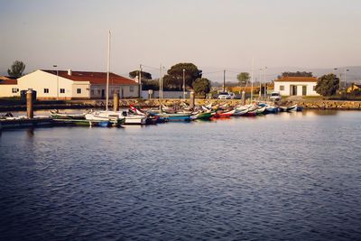 Boats moored in river against buildings in city