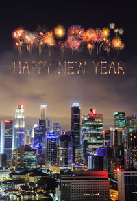 Firework display over illuminated buildings in city at night