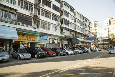 Cars on road by buildings in city