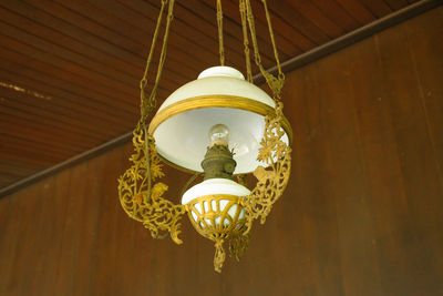 Low angle view of illuminated pendant light hanging on ceiling