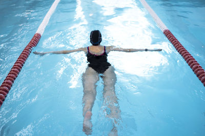 Rear view of woman swimming in sea