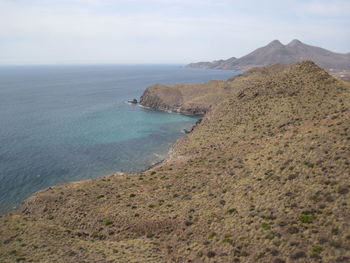 Scenic view of sea and mountains against sky