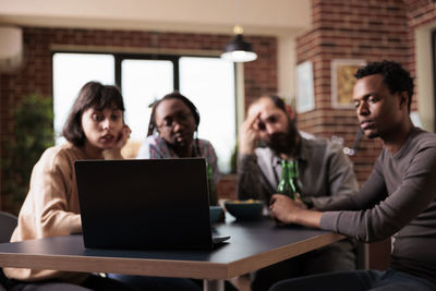 Friends using laptop at home