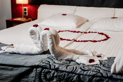 Close-up of towels on bed forming a heart at home