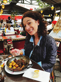 Portrait of smiling woman having food at restaurant