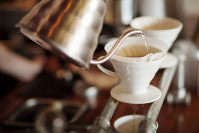 Water being poured from kettle into coffee filter at cafe