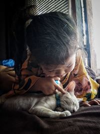 Cute girl playing with kitten at home
