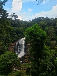 Scenic view of waterfall against sky