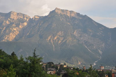 Scenic view of townscape and mountains against sky