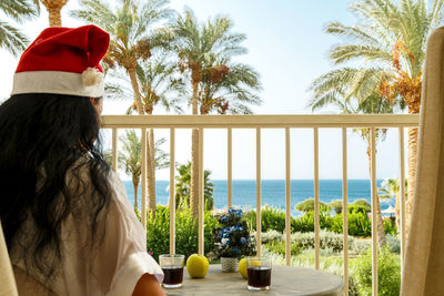 Rear view of woman looking at sea against sky