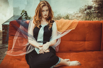 Portrait of young woman sitting outdoors