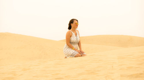 Woman kneeling at desert