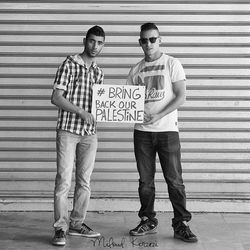 Full length portrait of friends standing against wall