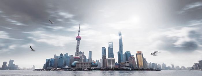 View of skyscrapers against cloudy sky