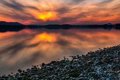 Scenic view of lake against orange sky