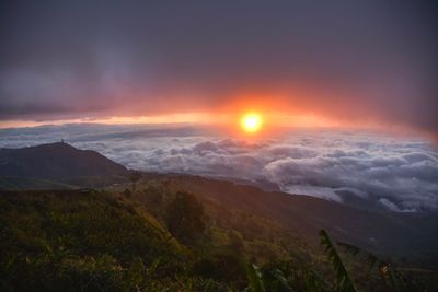 Scenic view of landscape against dramatic sky during sunset