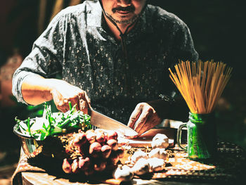 Midsection of man holding food on table