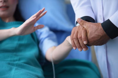 Midsection of doctor examining female patient at hospital