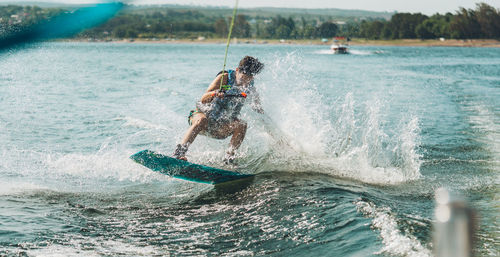 Full length of man wakeboarding in sea