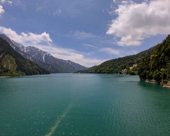 Scenic view of lake by mountains against sky