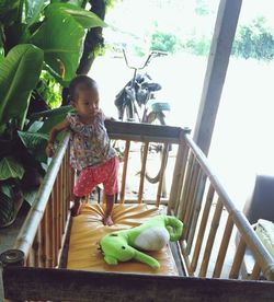 Cute baby girl sitting on railing