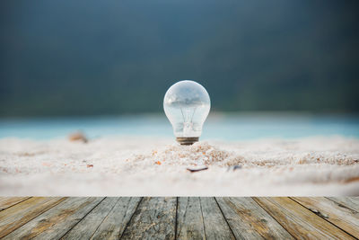 Close-up of light bulb on table