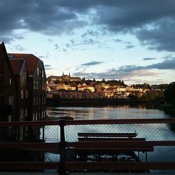 River in city against cloudy sky