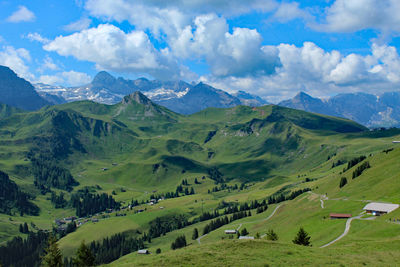 Panoramic view of green landscape and mountains against sky