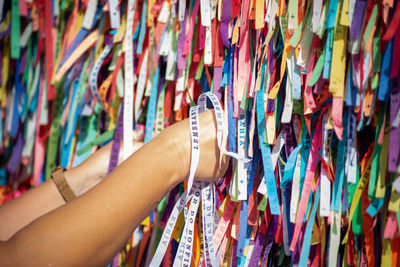 A catholic faithful is seen tying a souvenir ribbon on the railing of the senhor do bonfim church