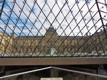 Low angle view of glass building against sky